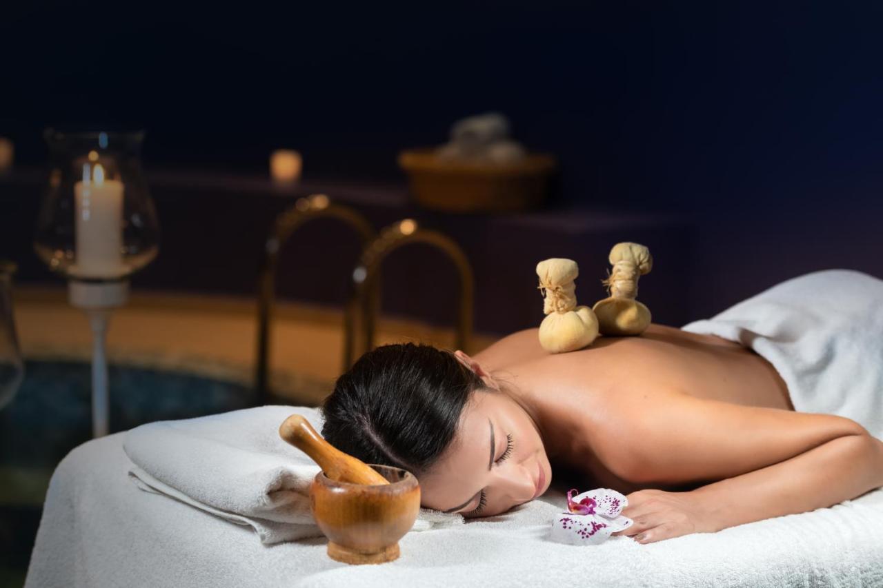 Santorini Kastelli Resort Kamári Dış mekan fotoğraf A woman receiving a massage with hot stones